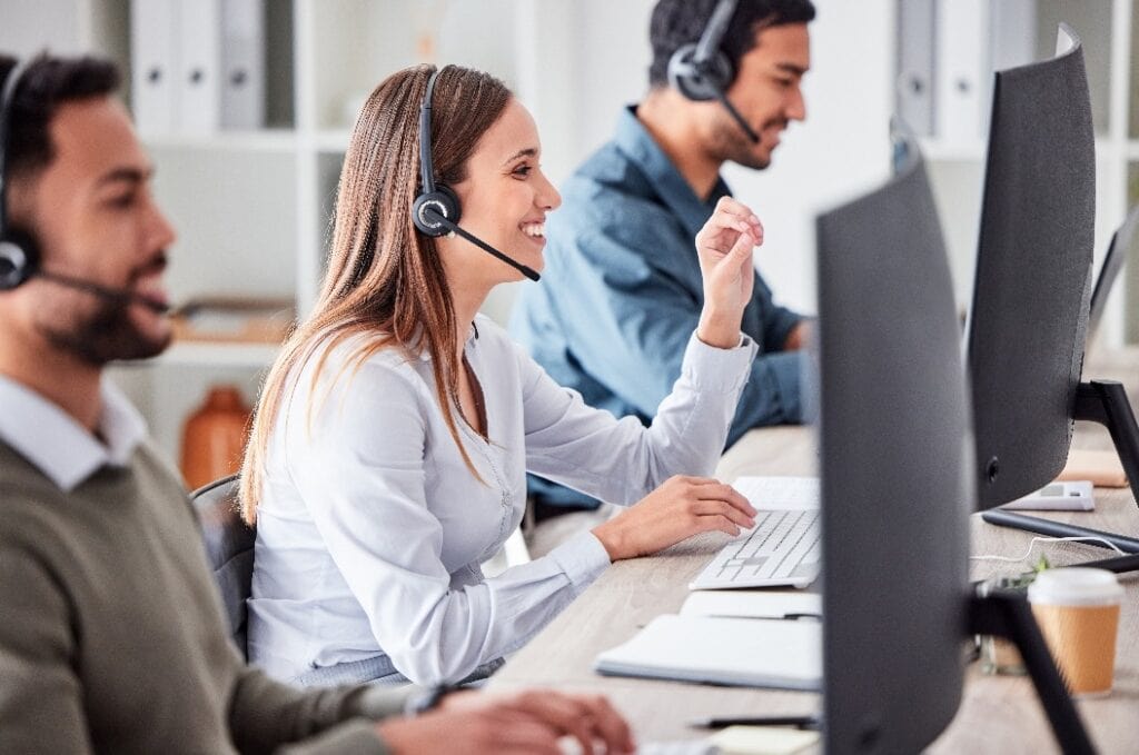 Callcenter, Frau und Arbeit im Team Büro mit Headset, Computer und Online-Kundenbetreuung, Service oder Hilfe. Geschäftsfrau, Lächeln und Kontakt, crm und Telemarketing Mitarbeiter im Gespräch