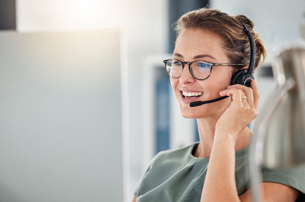 Glückliche Callcenter-Frau, die einen Kunden berät, wenn es um Kundenbetreuung, Hilfe oder Telemarketing-Verkauf geht.