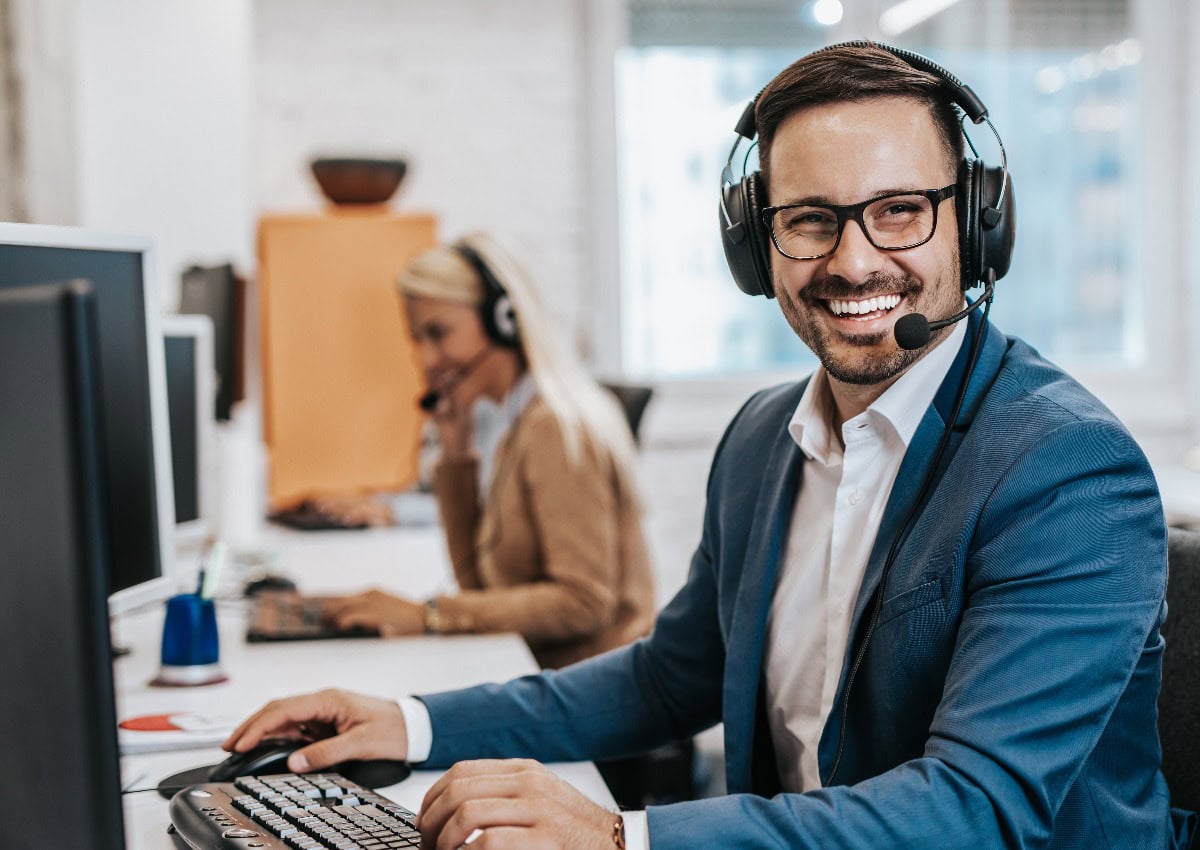 Gutaussehender männlicher Kundendienstmitarbeiter in einem Call Center Büro